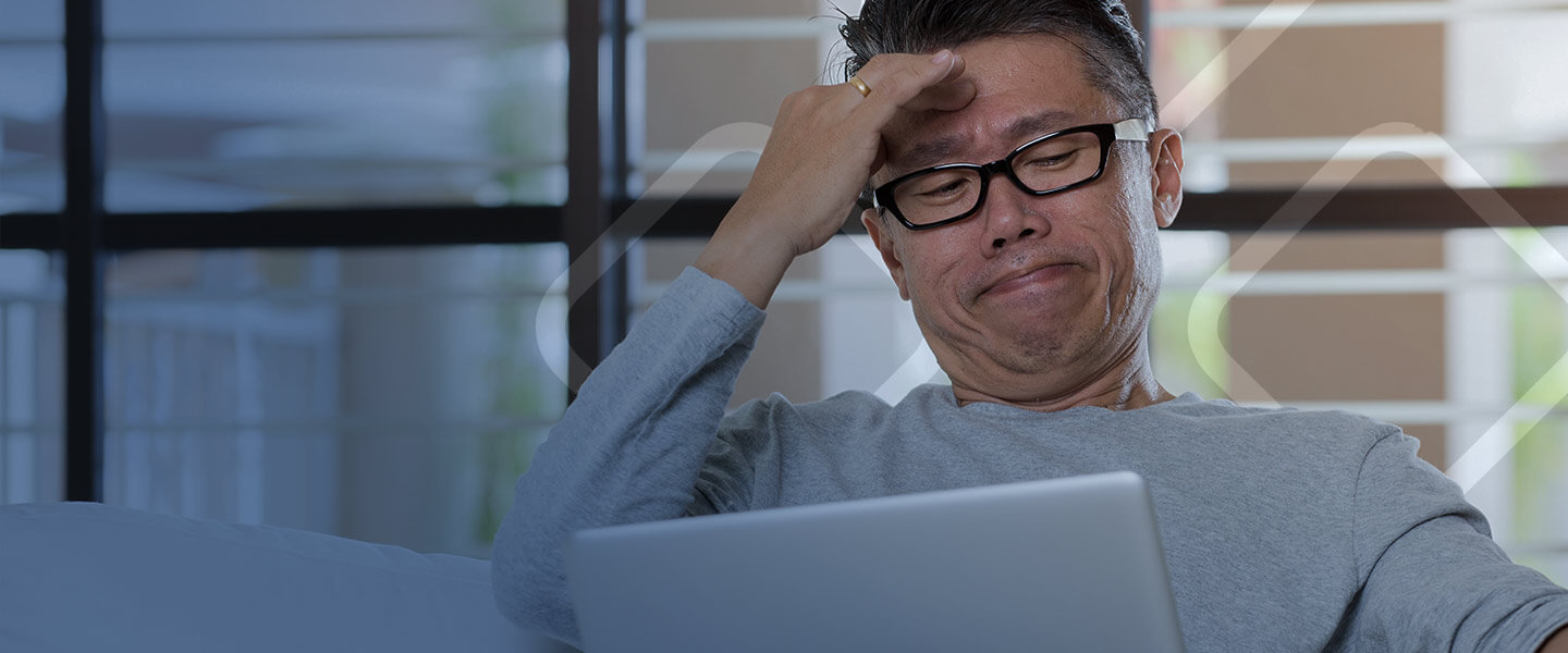 stressed man looking at laptop