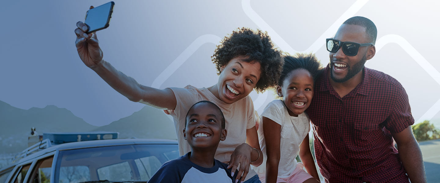 Happy family taking a selfie outside of their car