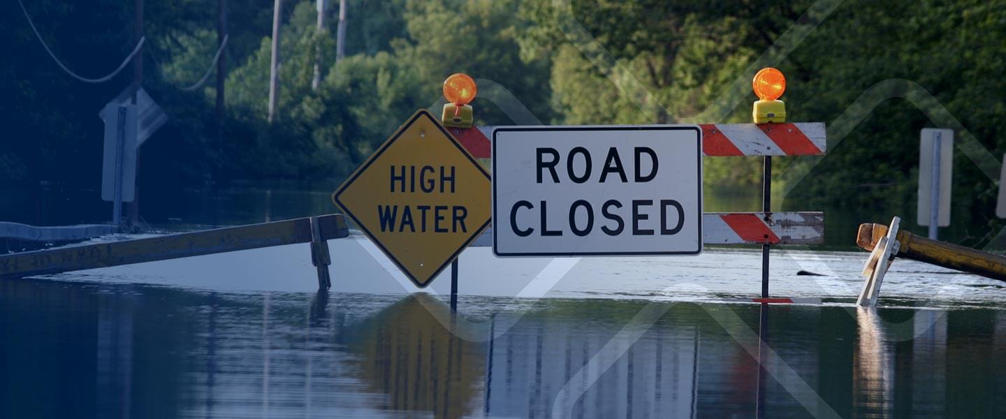 closed road sign with high water