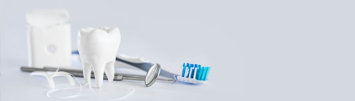 close up of tooth, floss, and toothbrush