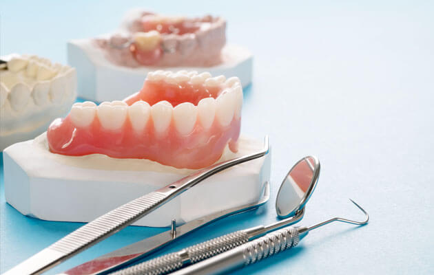 close up of dentures with dentistry tools