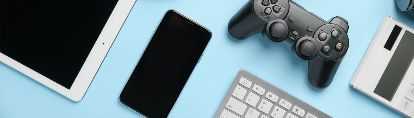 top view of game console controller, keyboard, cell phone, and tablet