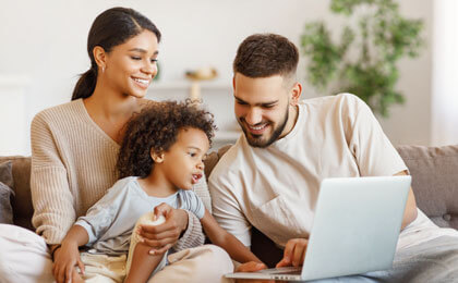 family with child looking at laptop