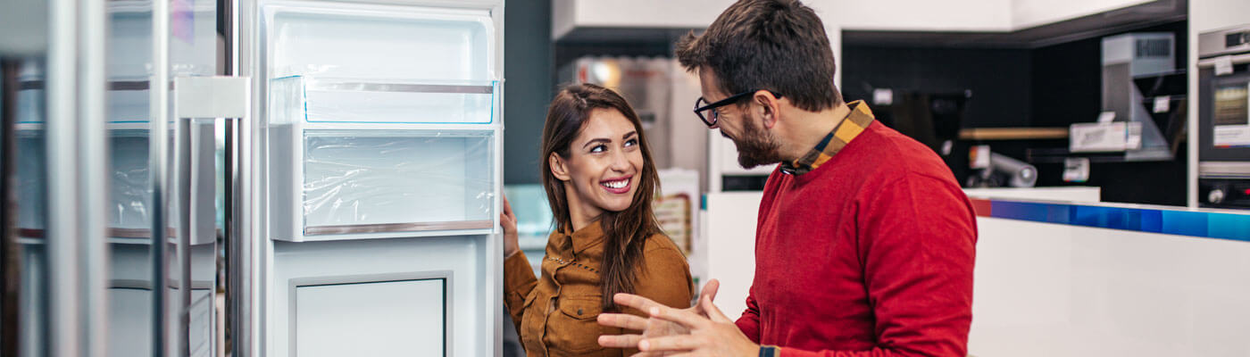 Couple shopping for fridges in store