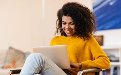 woman smiling using laptop in office chair