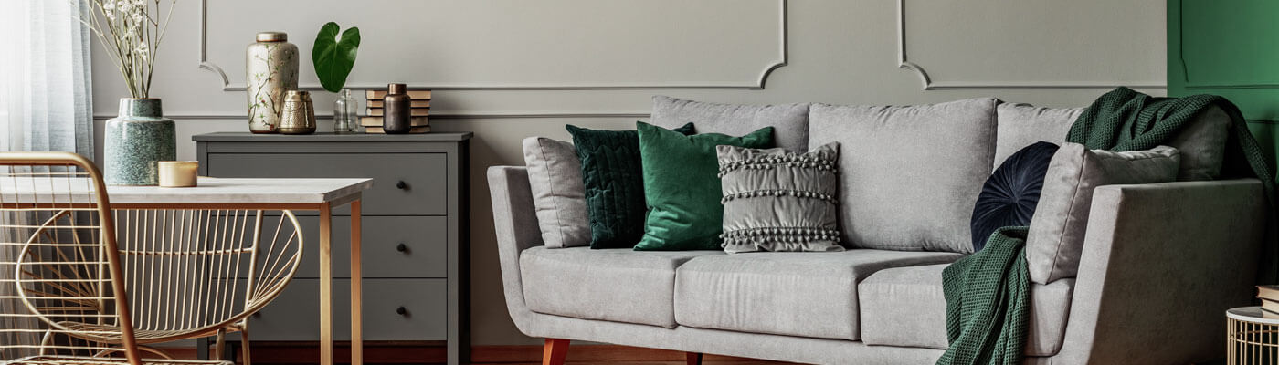 grey couch with green accents next to office desk