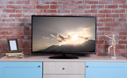 tv stand with flat screen in front of a brick wall