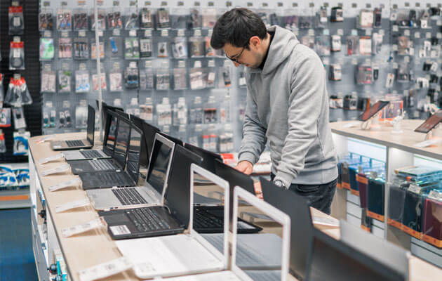 man shopping for laptops in computer store