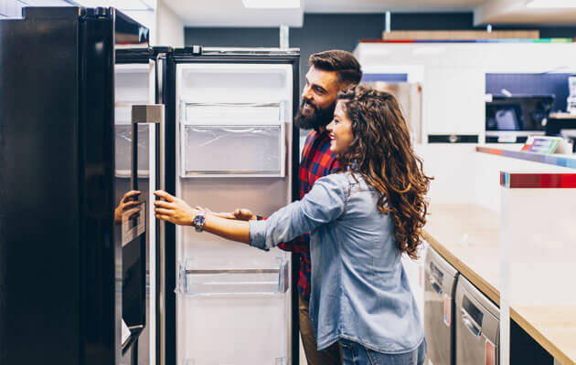 couple shopping for fridge in store