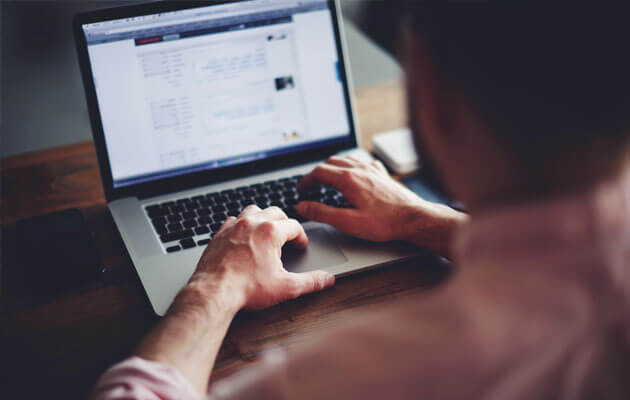 close up of mans hands typing on keyboard