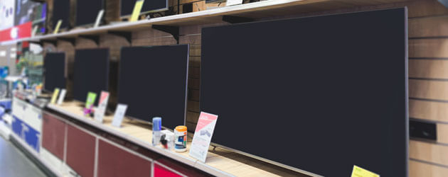 display of flat screen tvs in electronics store