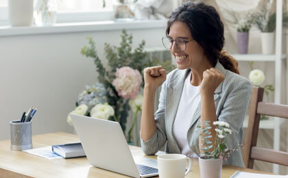 business woman excited looking at laptop