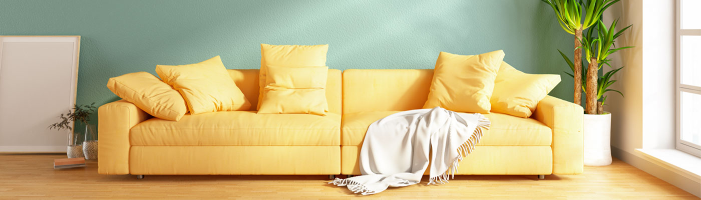 yellow couch in front of green wall