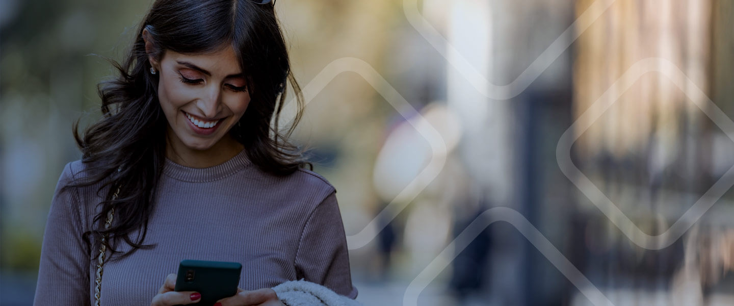 woman smiling walking while using phone