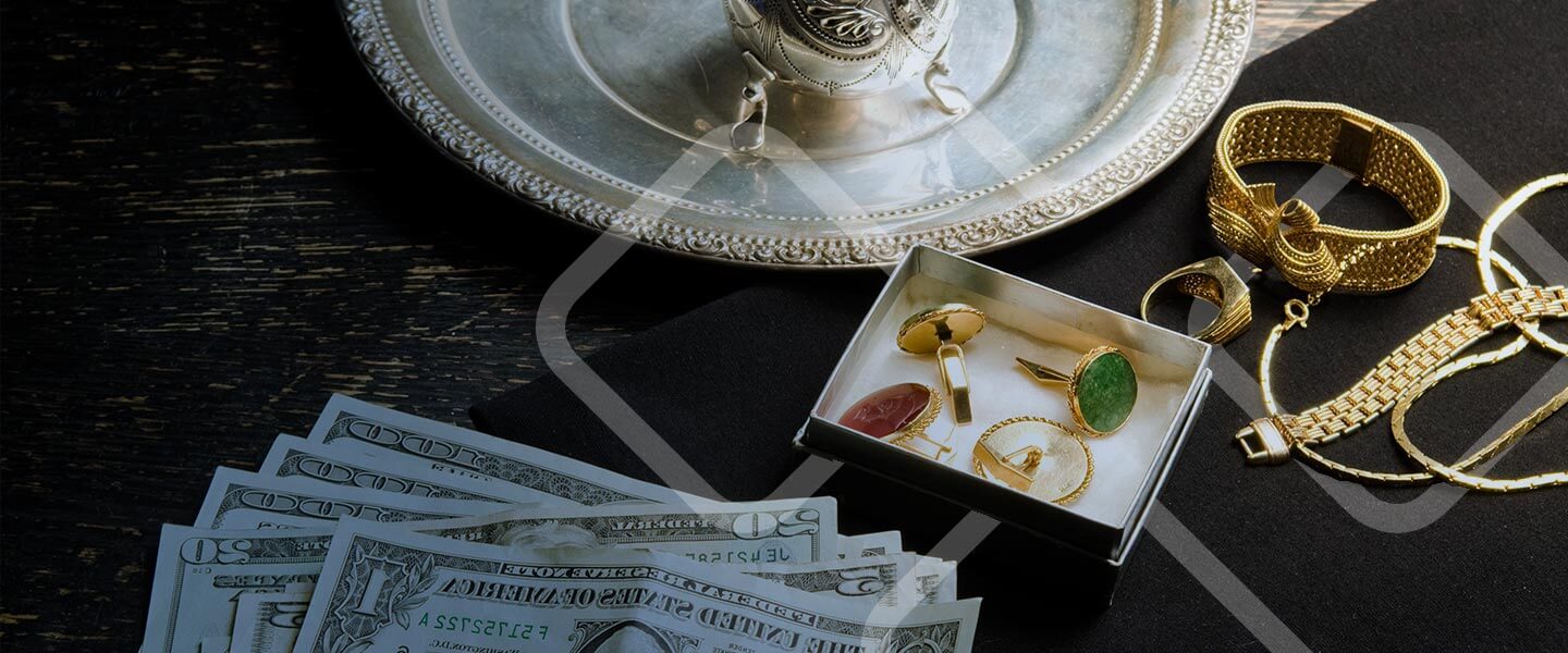 collectibles and gold jewelry and money on table