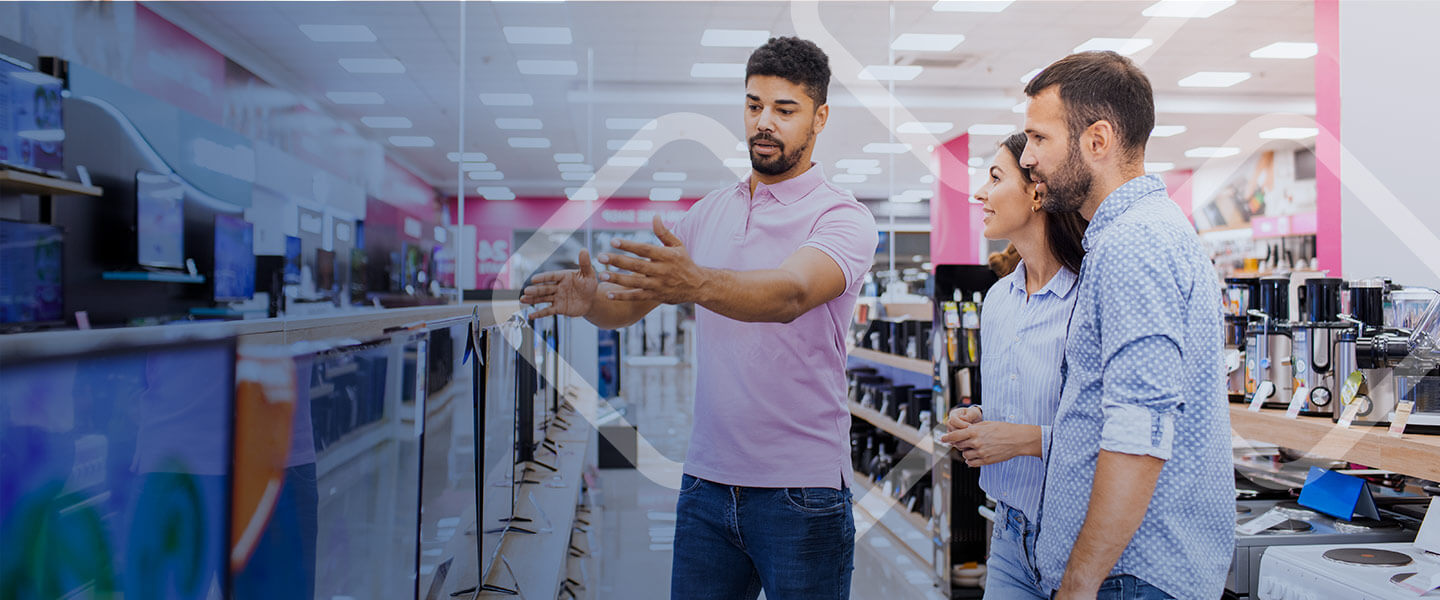 Couple is being assisted to buy tvs in electronics store