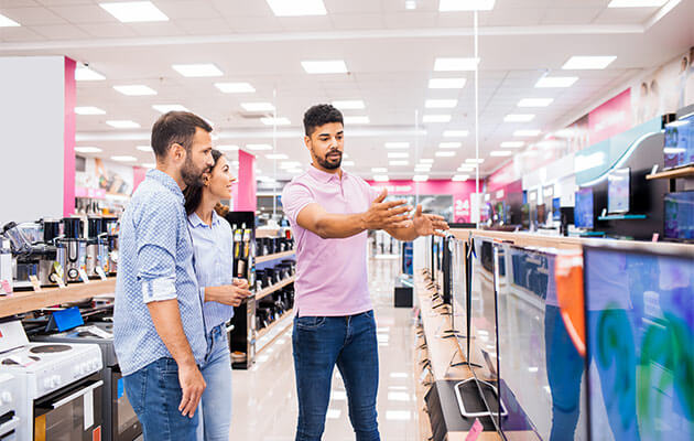 Couple is being assisted to buy tvs in electronics store