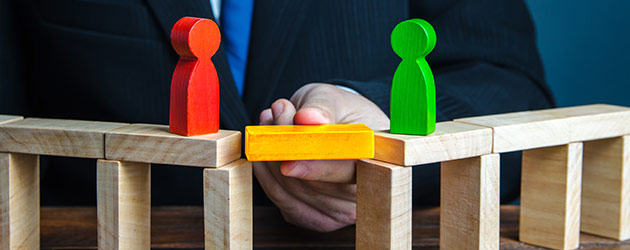 hand holding a block to bridge gap between figurines