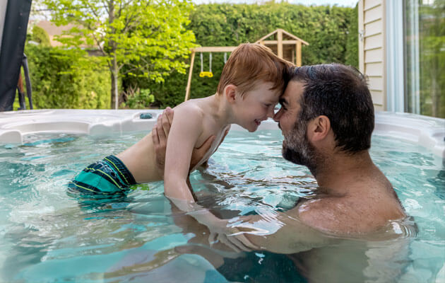 father son playing in hot tub