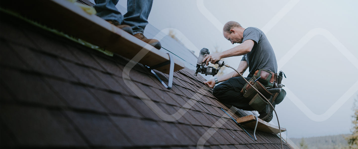 man installing shingles on roof repair