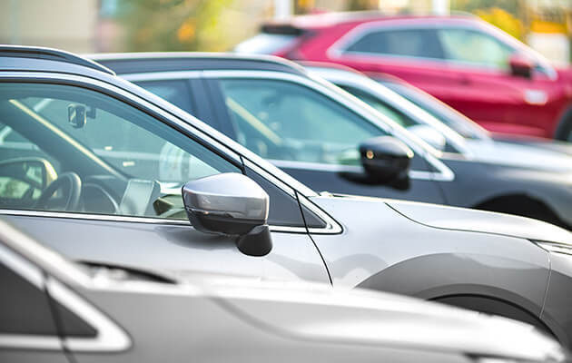 Side shot of a range of modern vehicles, at a public car dealership