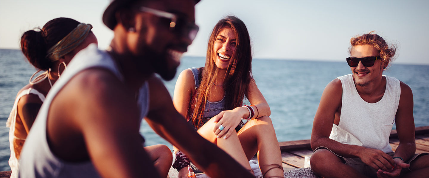 Friends relaxing on a dock over water.