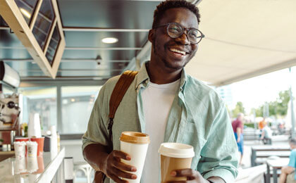 man with glasses smiling laughing with coffee