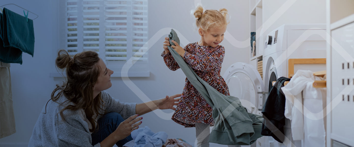 mother and daughter taking clothes out of dryer