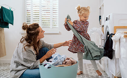 mother and daughter taking clothes out of dryer