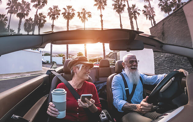 Senior couple driving in a convertible