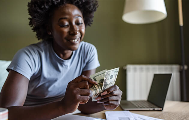 Happy woman counting cash.