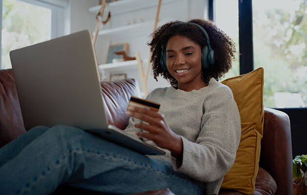 Happy woman with headphones shopping online.