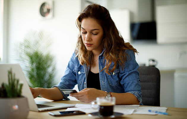 Young woman paying bills with credit card