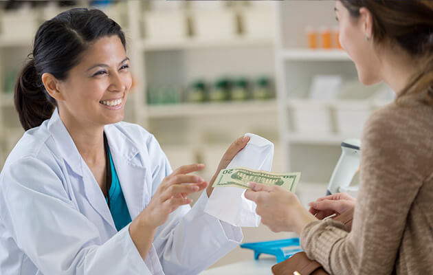 Woman paying for prescription at a pharmacy.