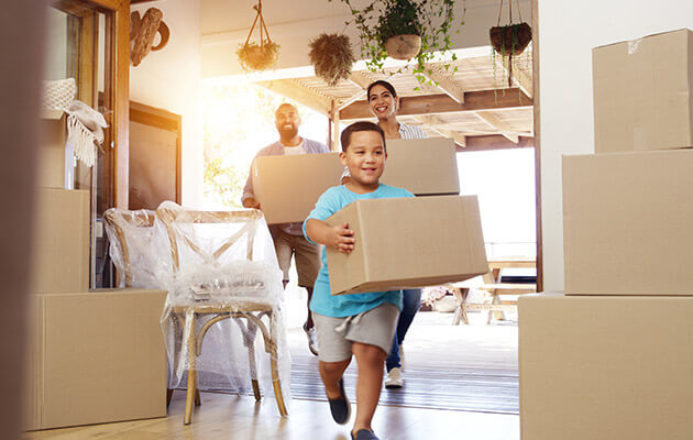 happy family moving boxes into new house