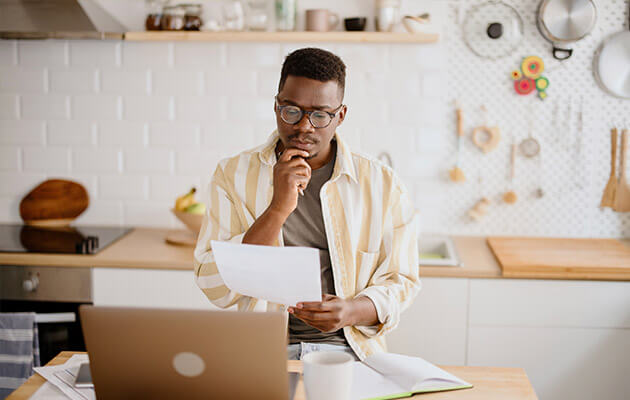 young man looking at paper and thinking