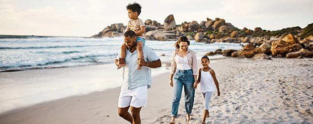 happy family walking on the beach together