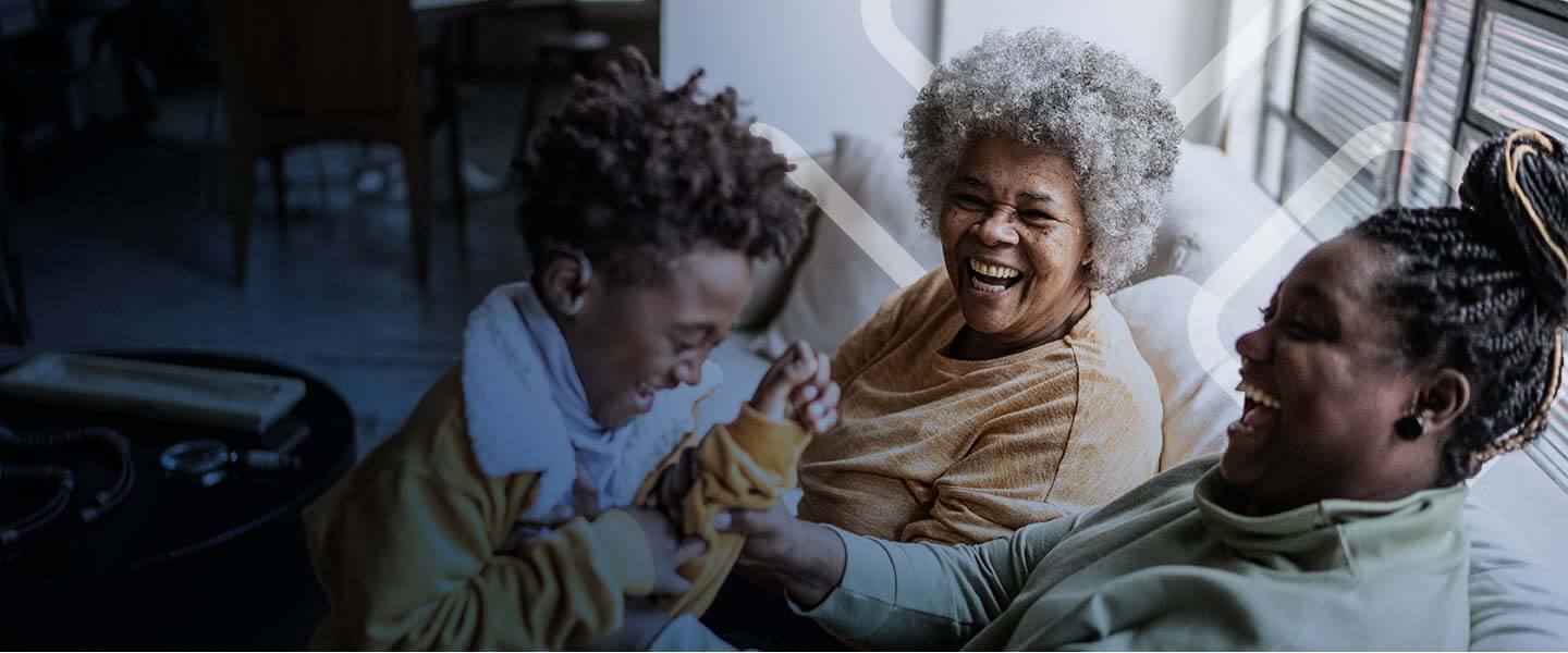 Grandma, mom and kid is having fun and laughing together on the couch