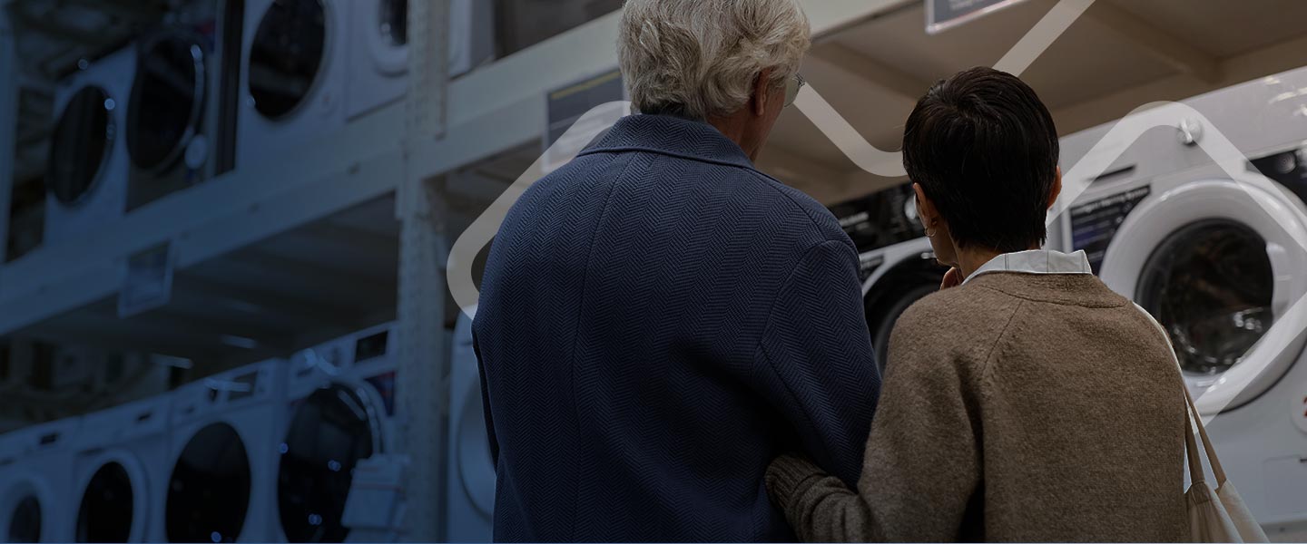 old couple looking and shopping for washers in store.