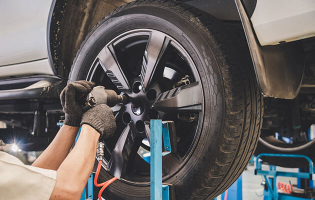 mechanic fixing and changing tires in stop