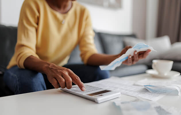 women using calculator to calculate bills